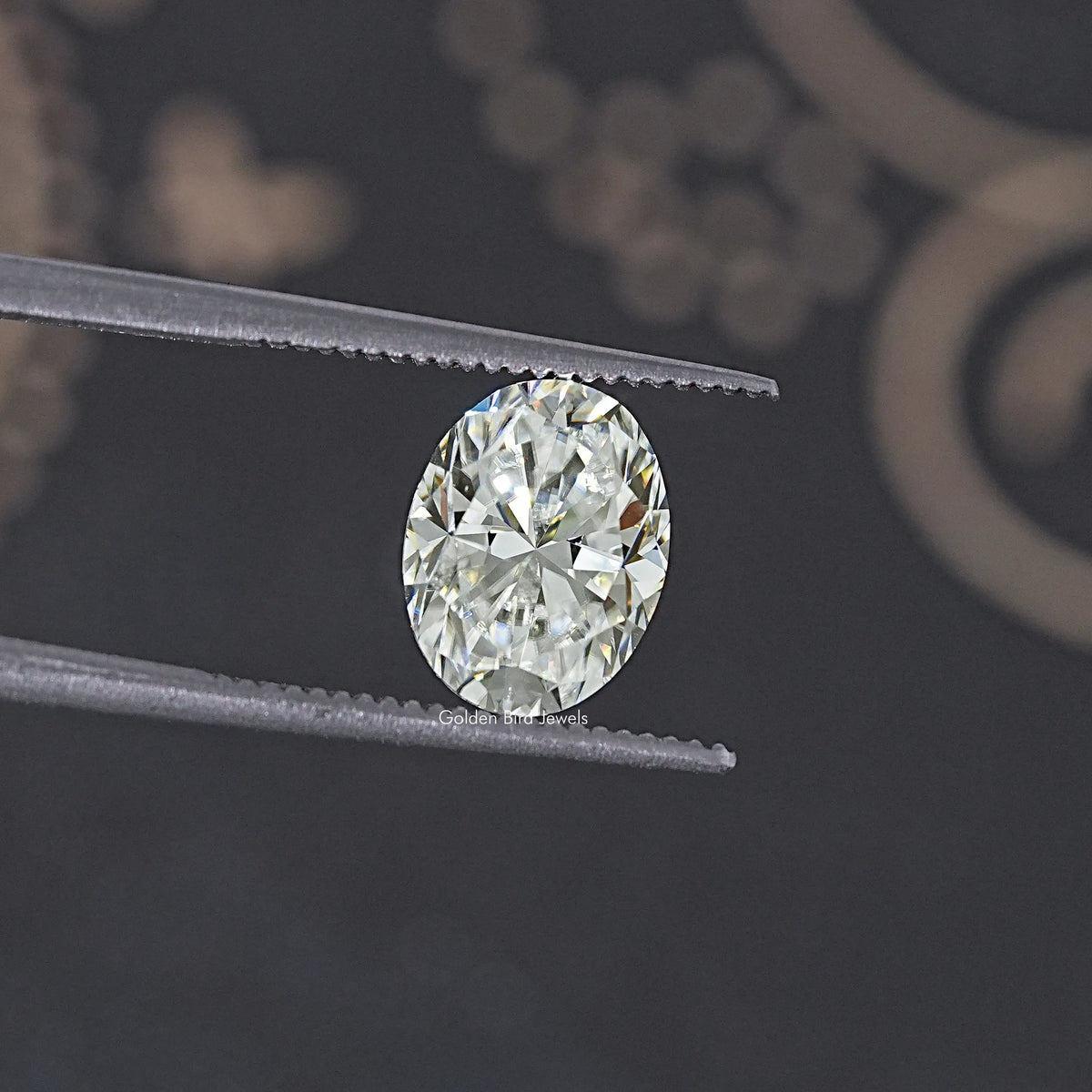 Oval moissanite loose stone, held in tweezers close-up, clear white