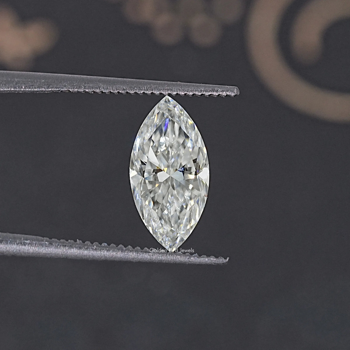 Pear-shaped moissanite loose stone held in tweezers, clear facets