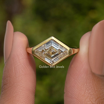 Lozenge-cut moissanite solitaire ring with gold bezel setting on sterling silver band