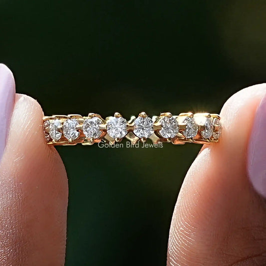 Gold-tone round moissanite wedding band with small round stones across the top