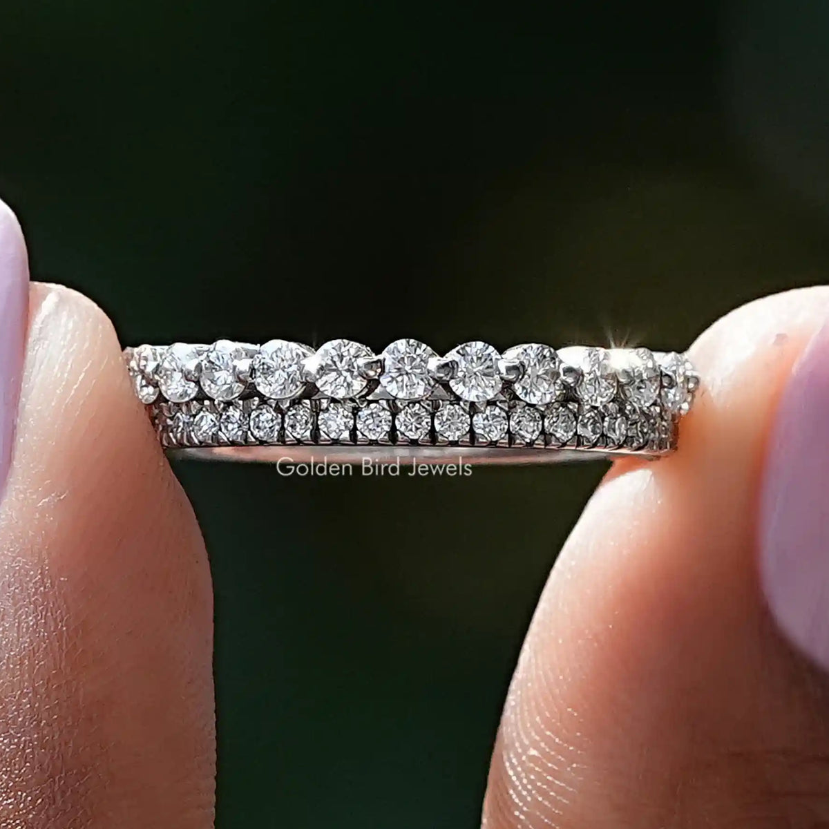Close-up of silver two-row eternity band ring with round diamonds across top