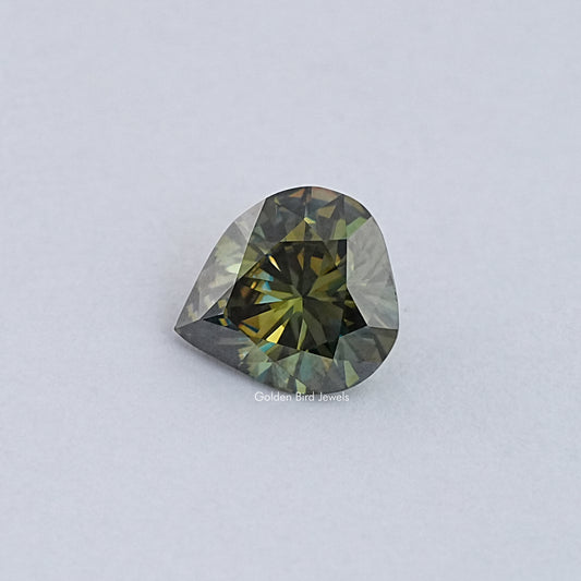 Pear-cut moissanite loose stone with dark green and gold facet reflections