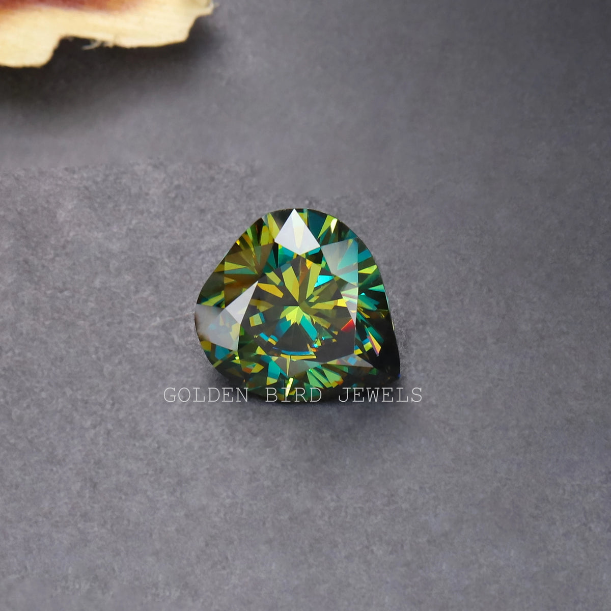 Dark green pear-cut moissanite loose stone, faceted with bright green highlights