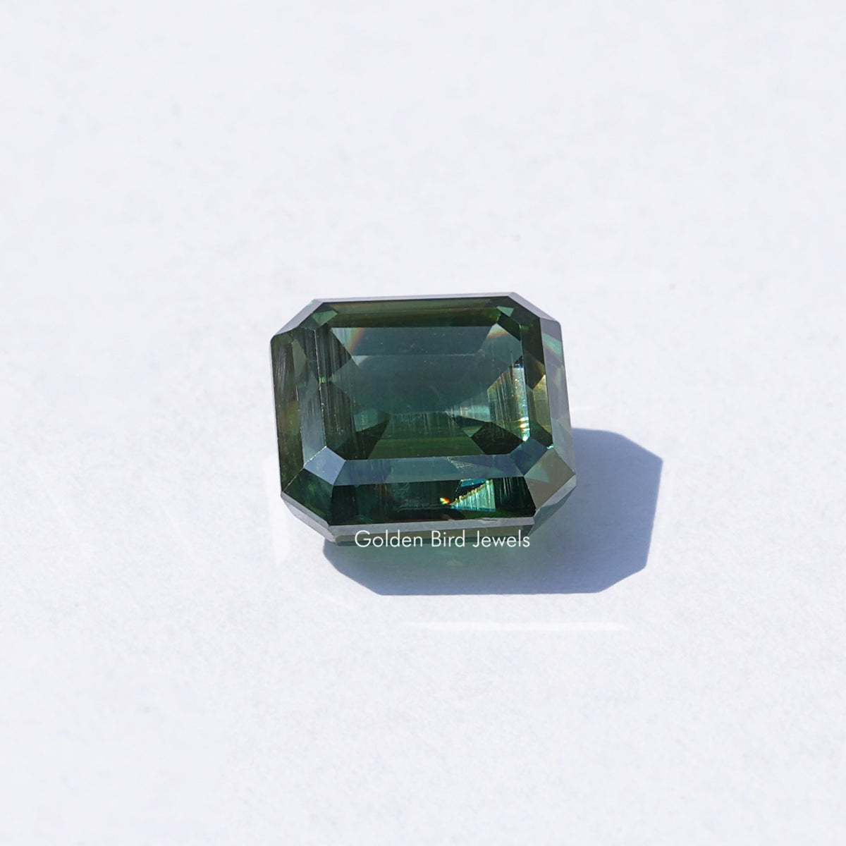 Green emerald-cut loose moissanite gemstone, dark green step-cut facets