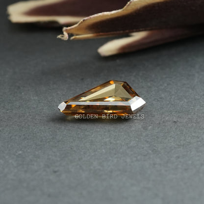 Loose golden rectangular step-cut moissanite stone with faceted edges