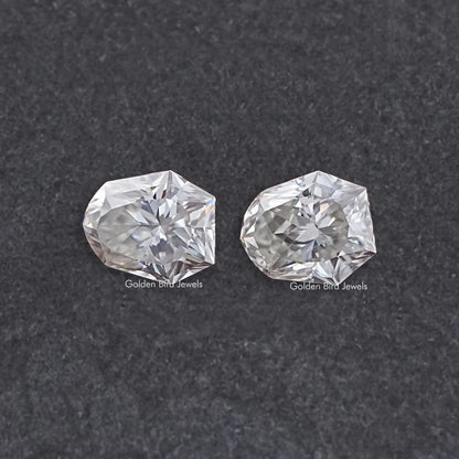 Shield-cut moissanite gemstones pair, clear faceted stones with matching shape