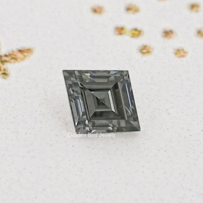 Gray lozenge-cut moissanite with deep step facets, close-up.