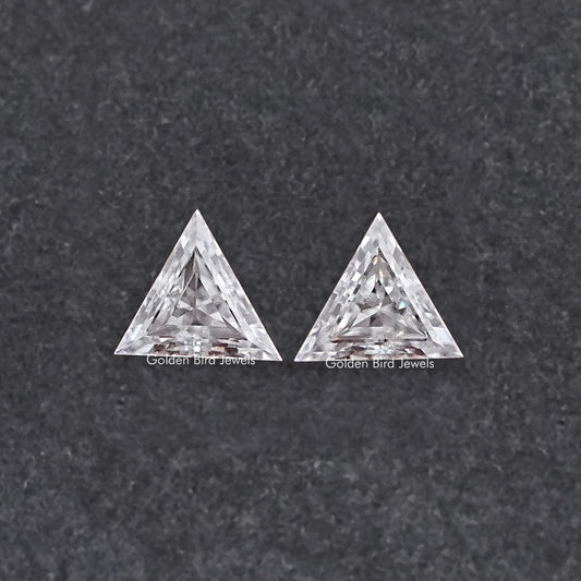Two triangle-cut clear moissanite stones, faceted front view