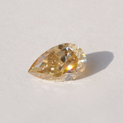 Pear-cut champagne moissanite loose stone, golden faceted sparkle.