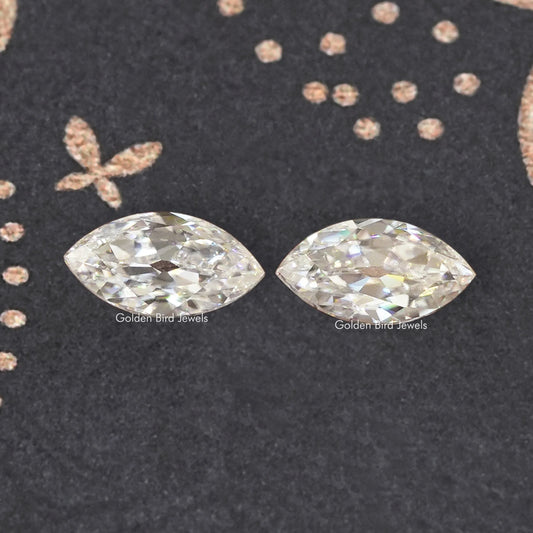 Two marquise-cut moissanite stones, close-up flat lay