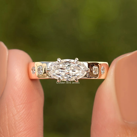 Gold moissanite ring with oval center stone and three side stones, front view