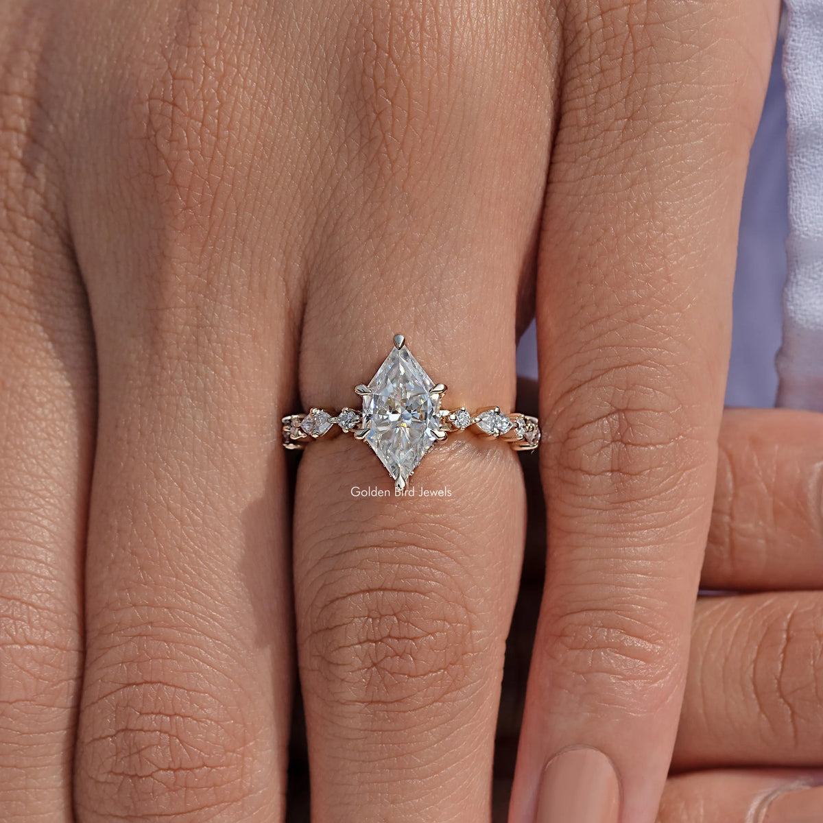 Gold-tone ring with marquise center moissanite and small round side accents