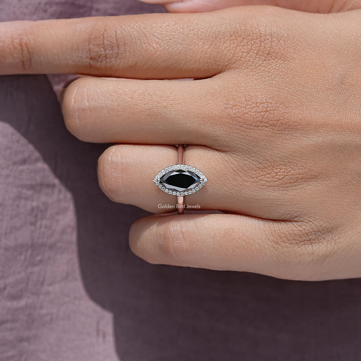 Close-up of sterling silver halo marquise ring on fingers
