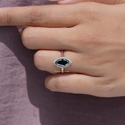 Close-up of sterling silver halo marquise ring on fingers