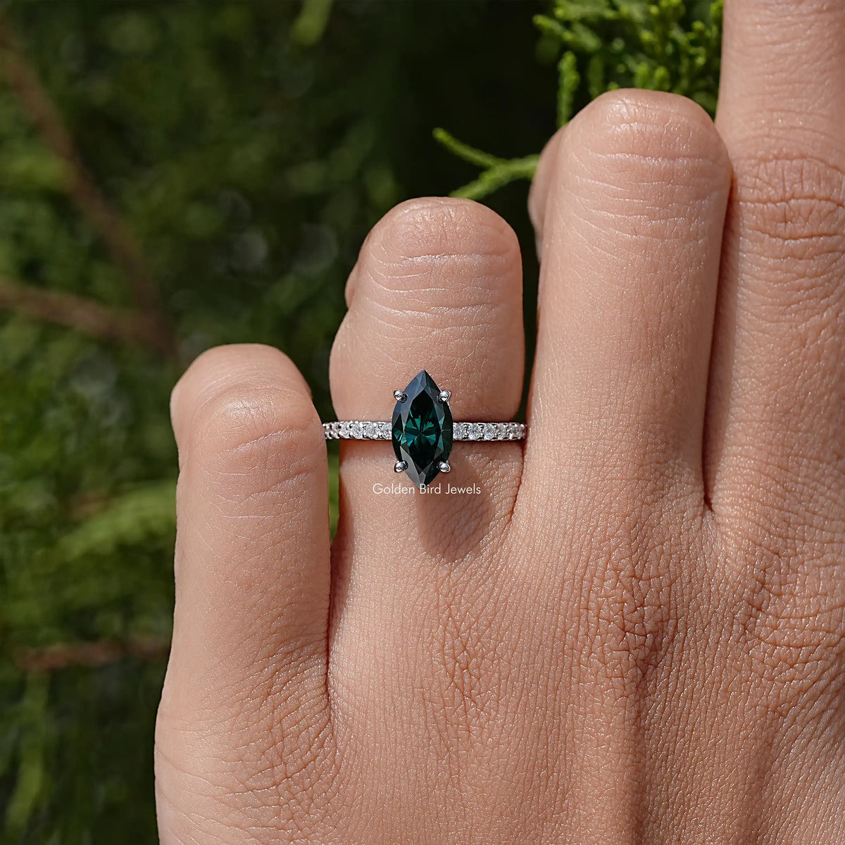 Marquise green moissanite solitaire accent ring on hand, sterling silver band.