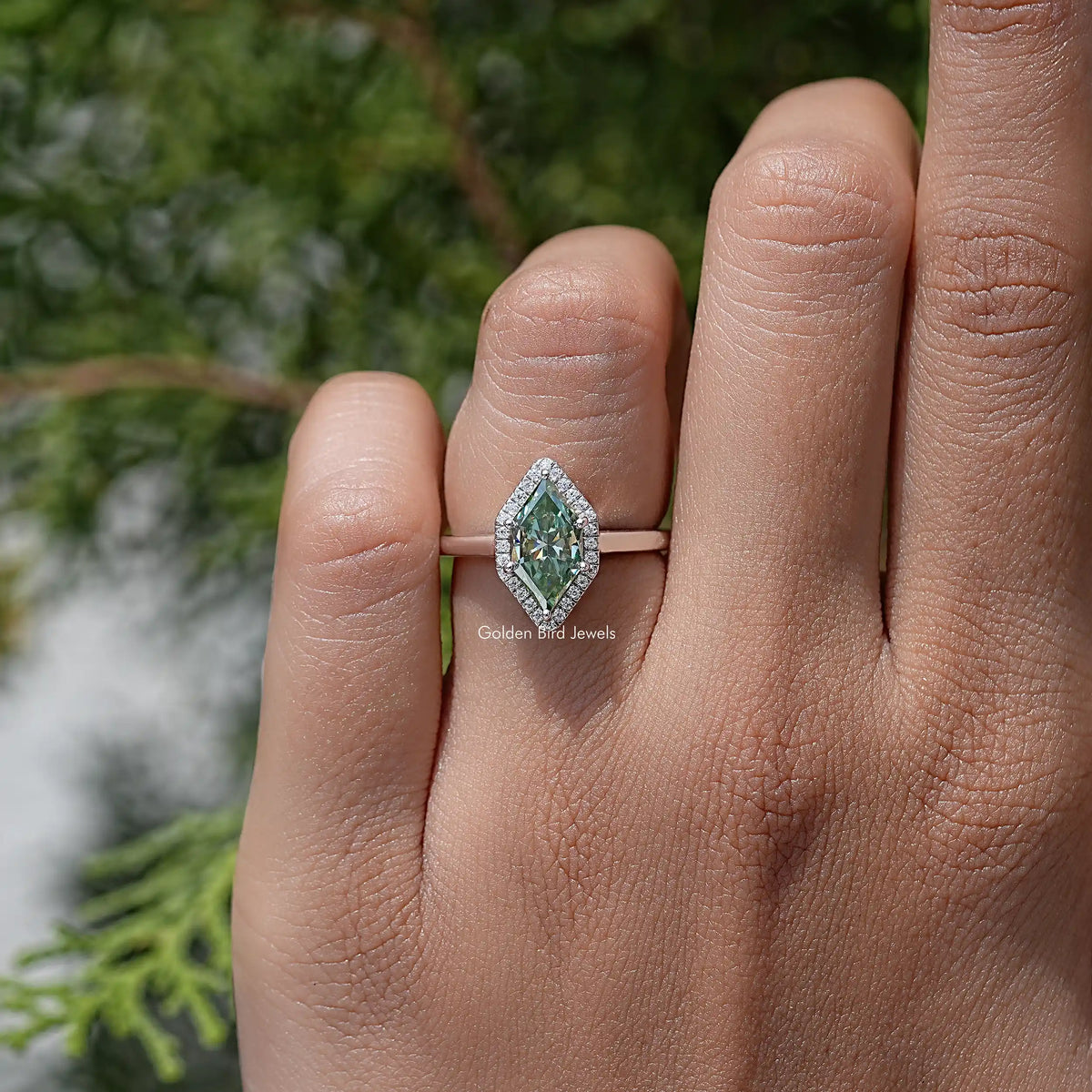 Sterling silver marquise moissanite halo wedding ring with green center stone, front view