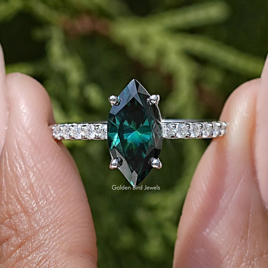 Marquise green moissanite center stone on sterling silver band with side sparkle accents.