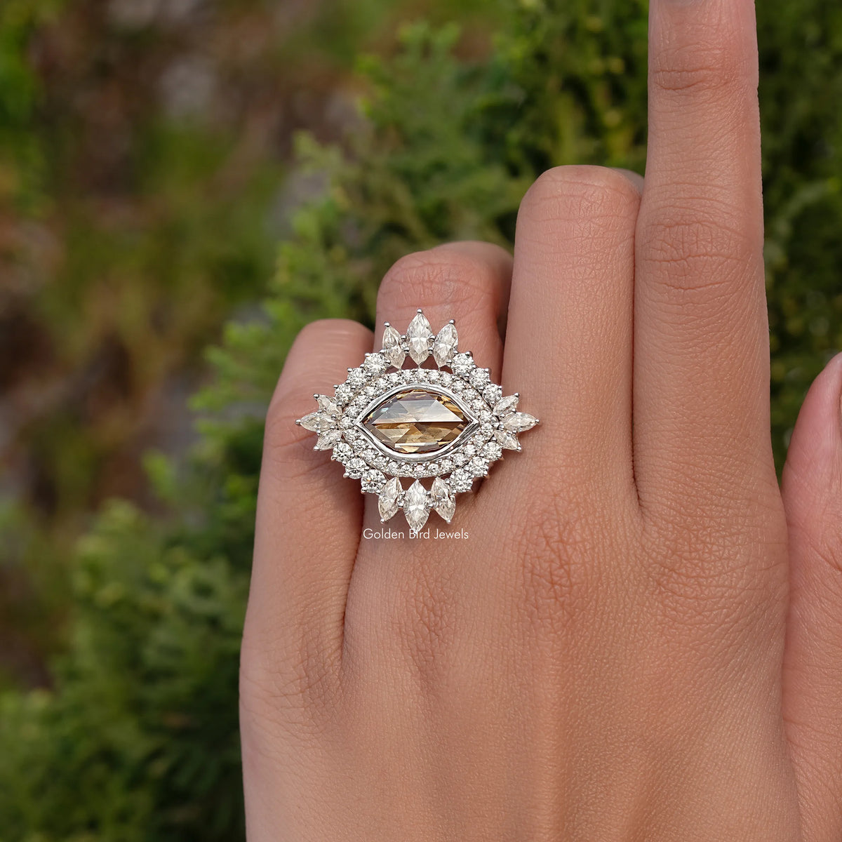 Champagne-toned marquise moissanite ring with ornate halo and glowing center stone