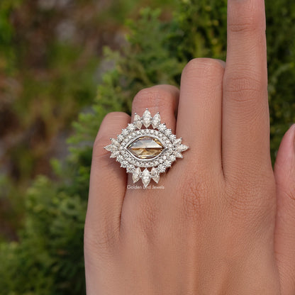 Champagne-toned marquise moissanite ring with ornate halo and glowing center stone