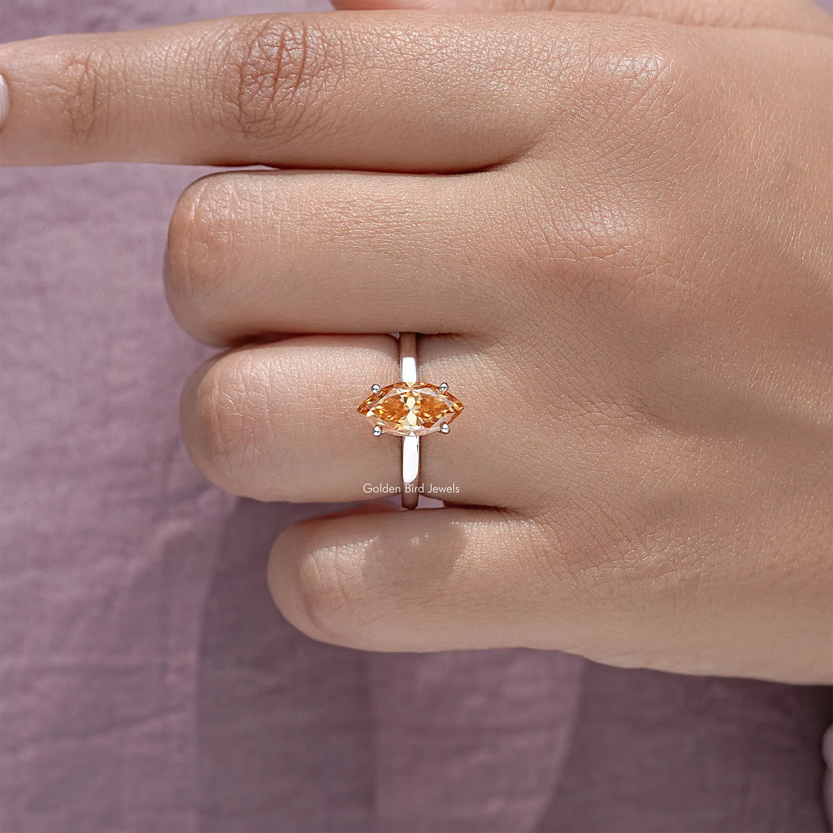 Silver solitaire ring with marquise-cut orange gemstone and slim band