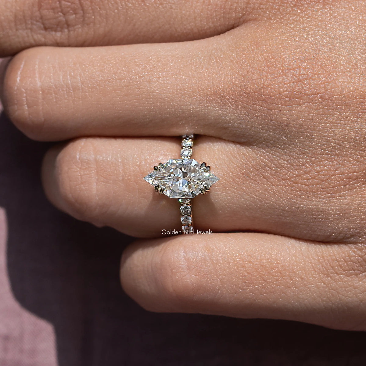 Silver marquise-cut moissanite ring with side pave details and four-prong center