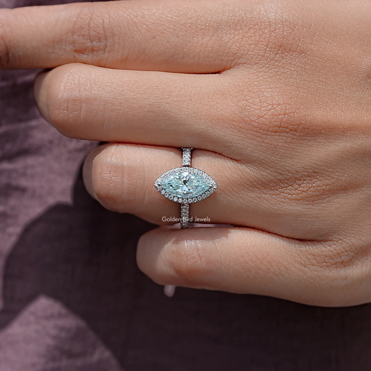 Blue marquise-cut moissanite accent bridal ring on a hand