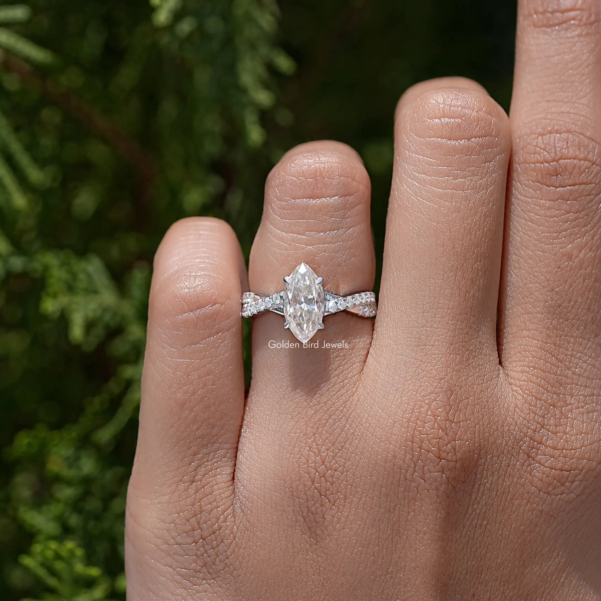 Twisted accent wedding ring on finger with marquise center stone and sparkling band