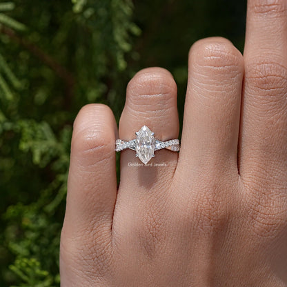 Twisted accent wedding ring on finger with marquise center stone and sparkling band