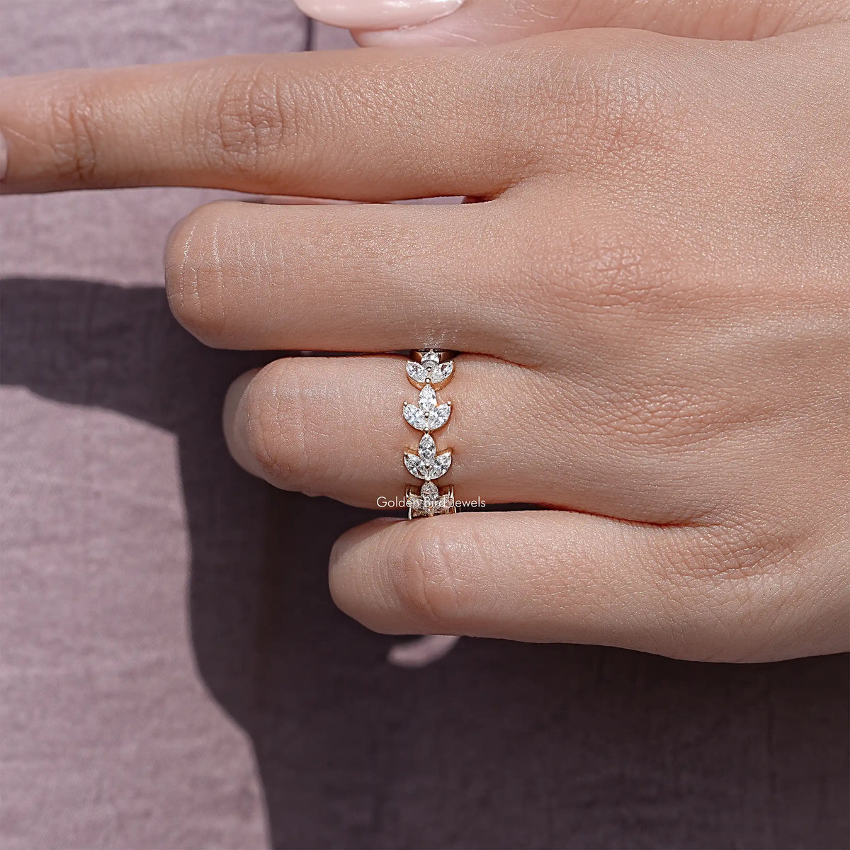 Dainty marquise lab diamond wedding band on finger, gold-tone prong set