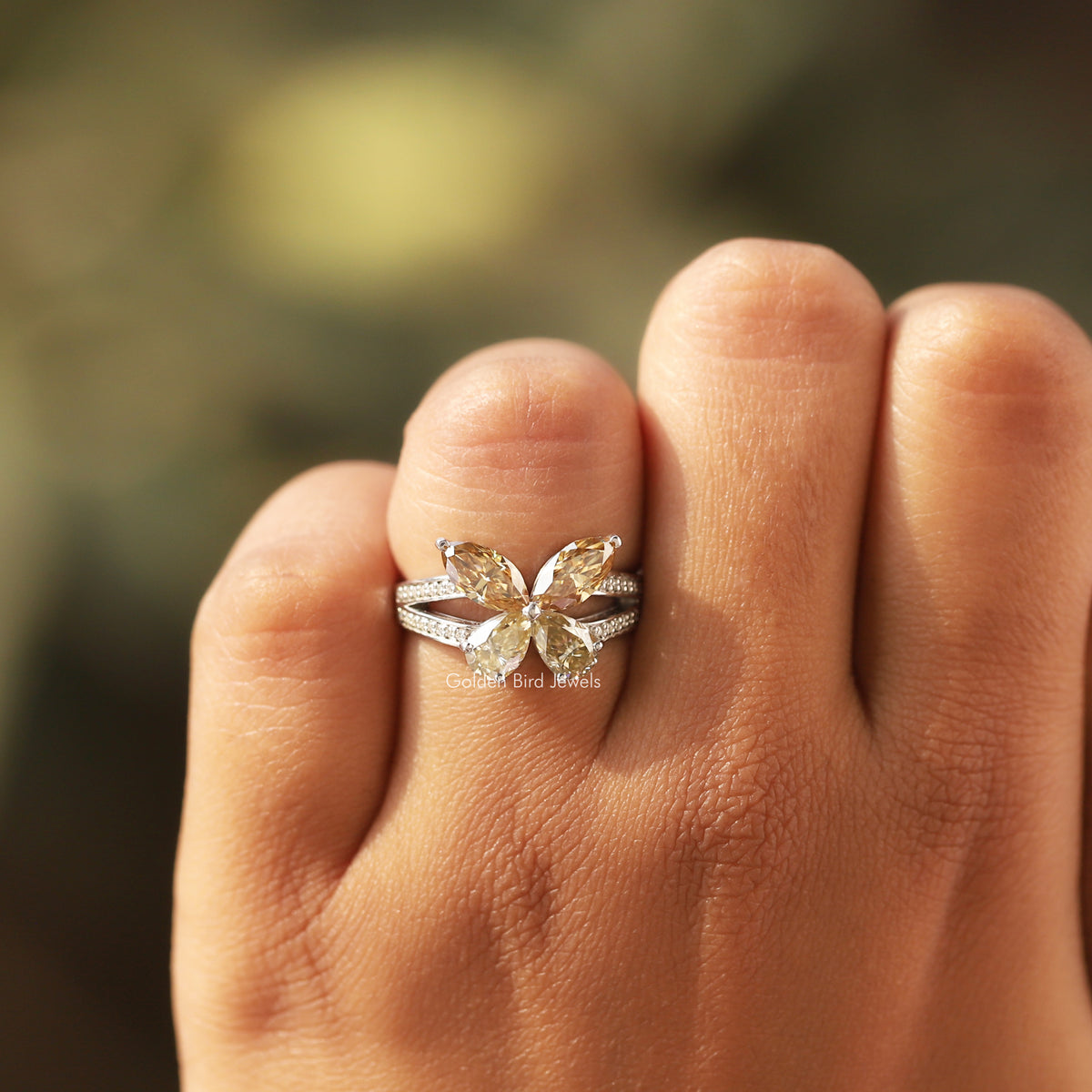 Butterfly marquise-cut moissanite engagement ring on hand, side view of pave details