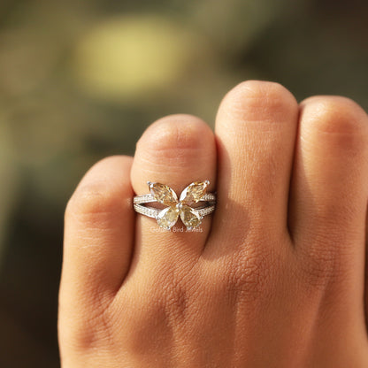 Butterfly marquise-cut moissanite engagement ring on hand, side view of pave details
