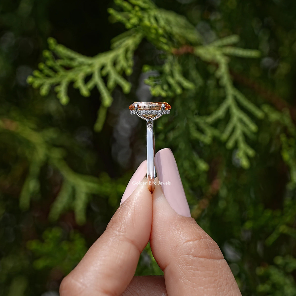 Marquise-cut moissanite hidden halo solitaire ring in sterling silver held between fingers