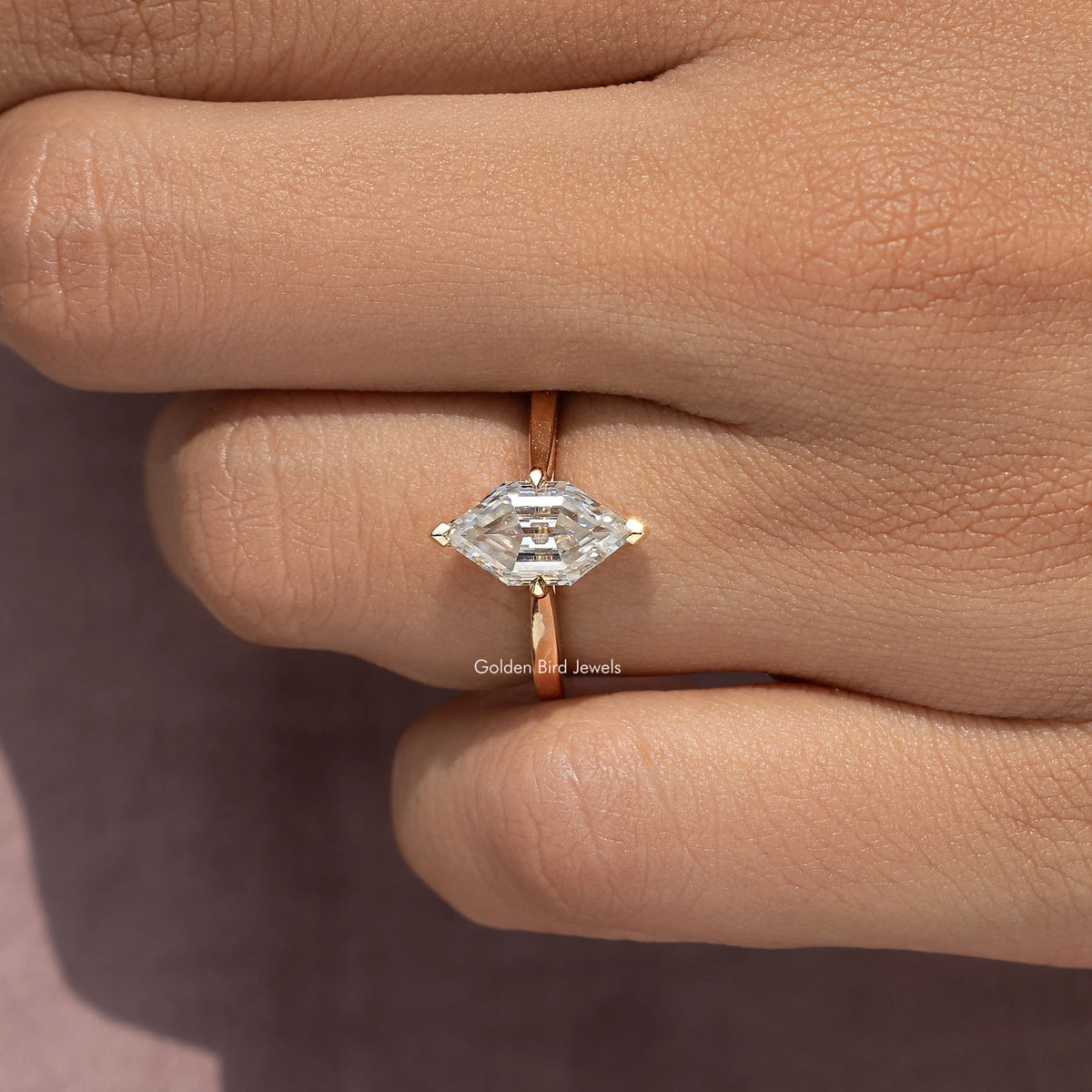 Gold-tone ring featuring a marquise step-cut moissanite center stone