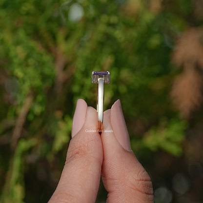 Open cuff ring underside view, showing prong-set emerald-cut dark blue stone