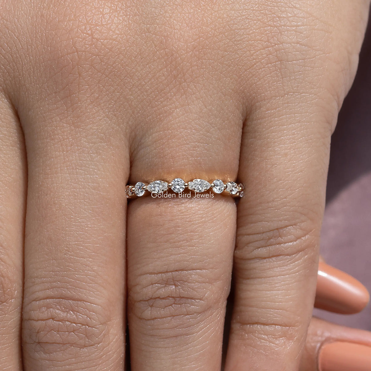 Lab-grown diamond wedding band with marquise-and-round stones, centered on hand