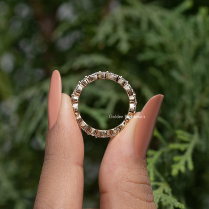 Lab-grown diamond wedding band with marquise and round stones, held on fingers