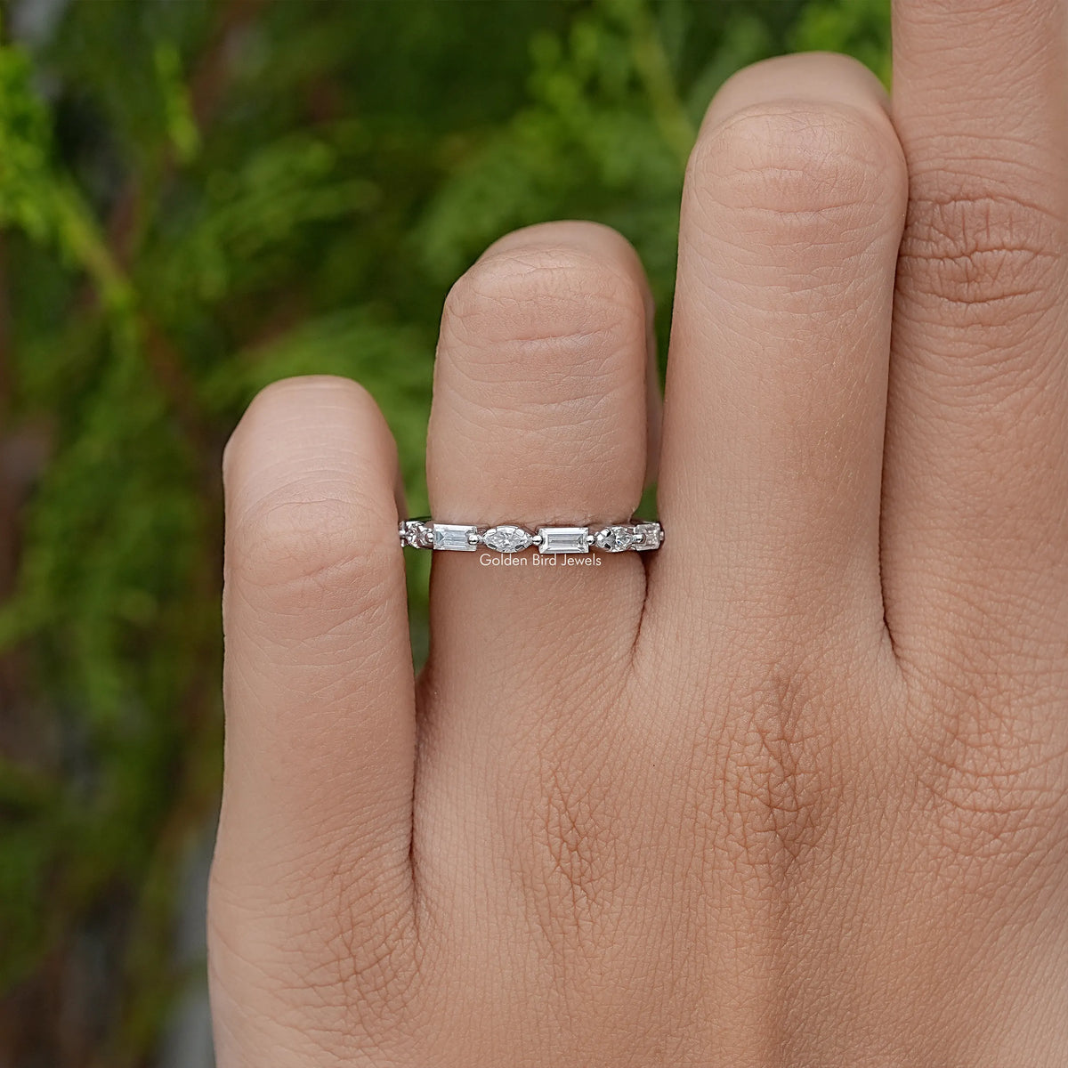 Silver marquise eternity wedding band on finger, front view
