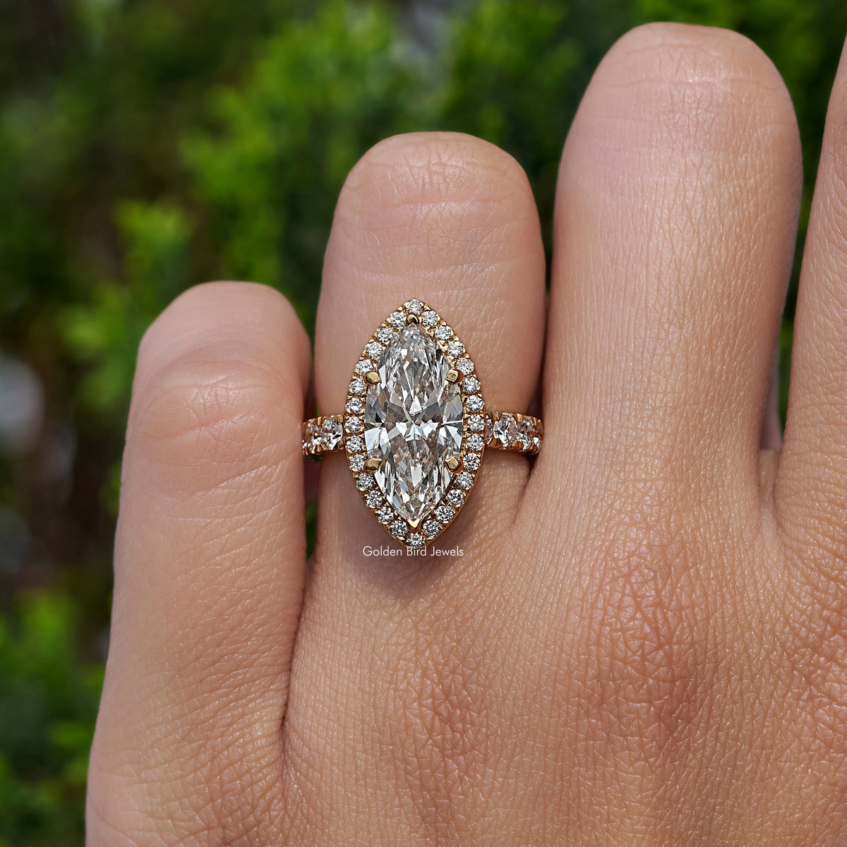 Marquise-cut center halo engagement ring with round accent shoulders, close-up