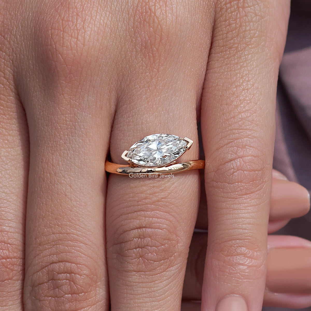 Rose-gold marquise-cut lab diamond solitaire ring, centered on finger
