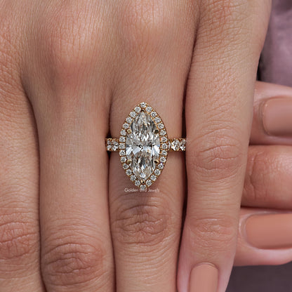 Marquise-cut halo engagement ring on hand, detailed prongs and side accents