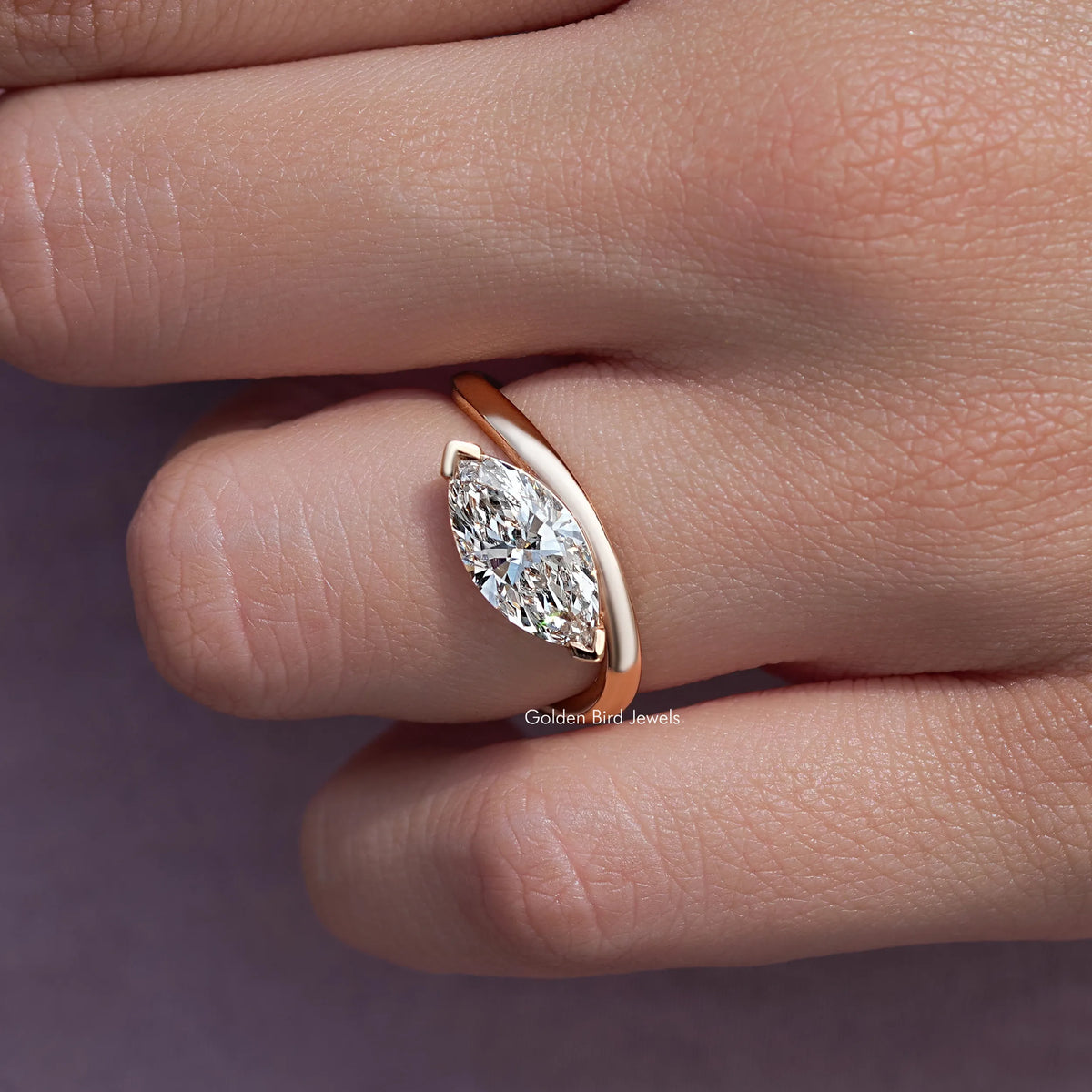Marquise-cut lab diamond in rose-gold curved solitaire setting, close-up