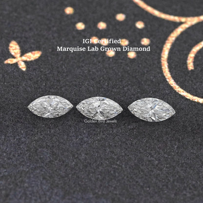 Three marquise-cut loose lab-grown diamonds on dark jewelry display fabric