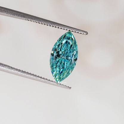Blue-green marquise-cut moissanite gemstone held in tweezers, angled view