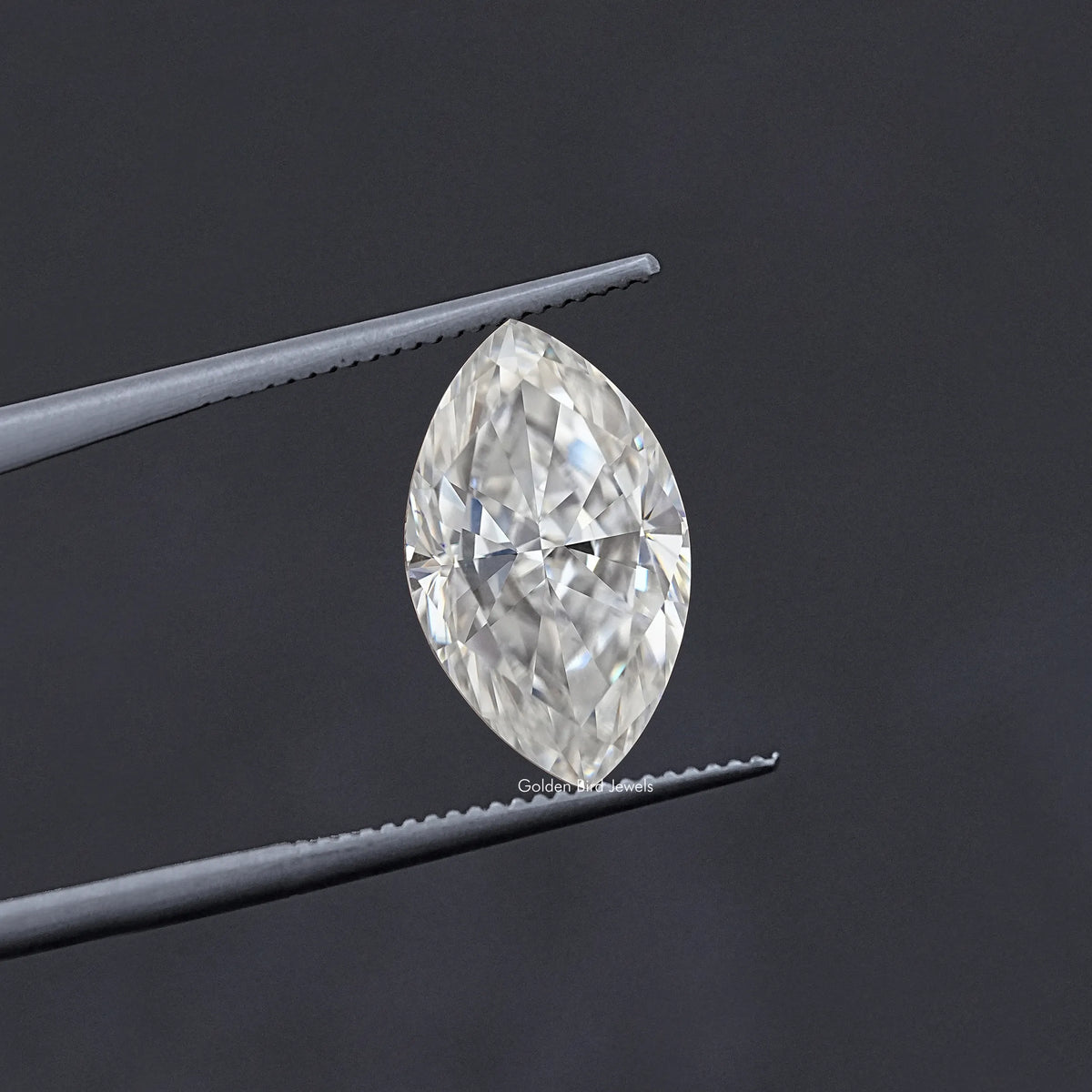 Marquise-cut moissanite stone held in tweezers, faceted clear white