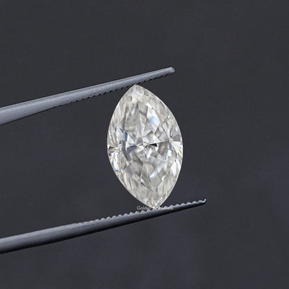 Marquise-cut moissanite stone held in tweezers, faceted clear white