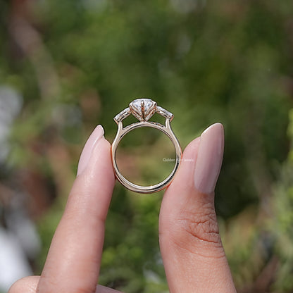 Three-stone bridal ring set showing round prongs holding a marquise-cut center stone