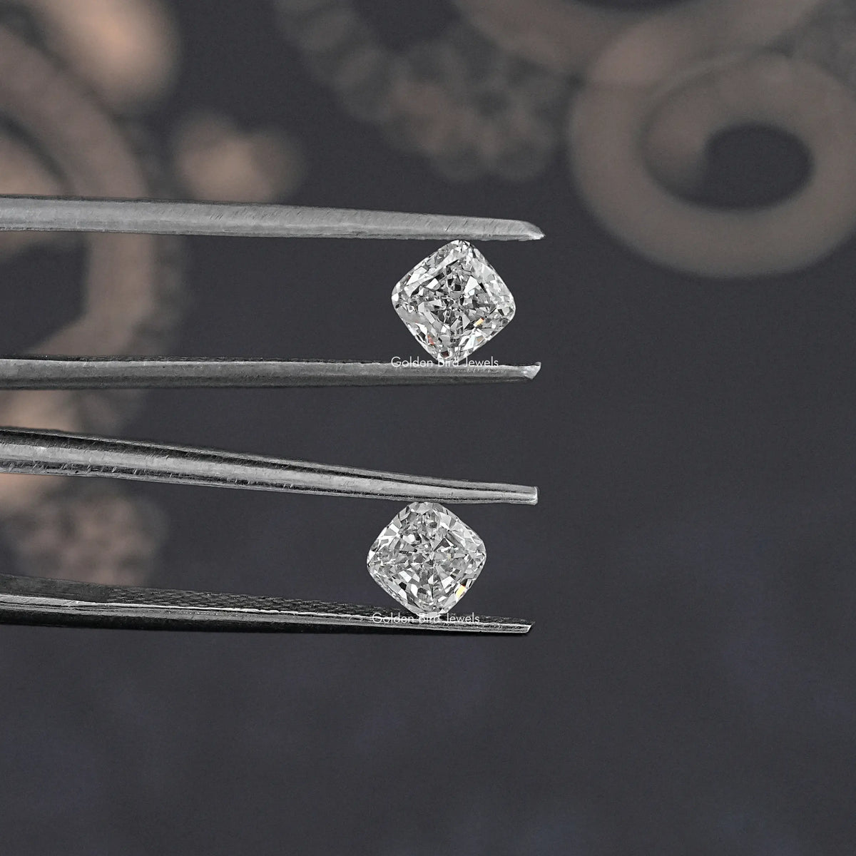 Two cushion-cut lab grown diamond studs held in tweezers, side view