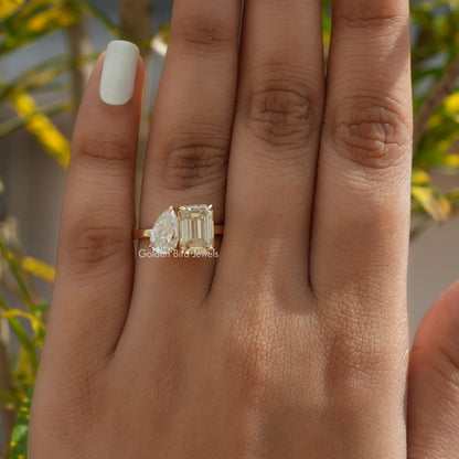 Two-stone toi et moi ring with prong-set stones on finger, gold-toned setting