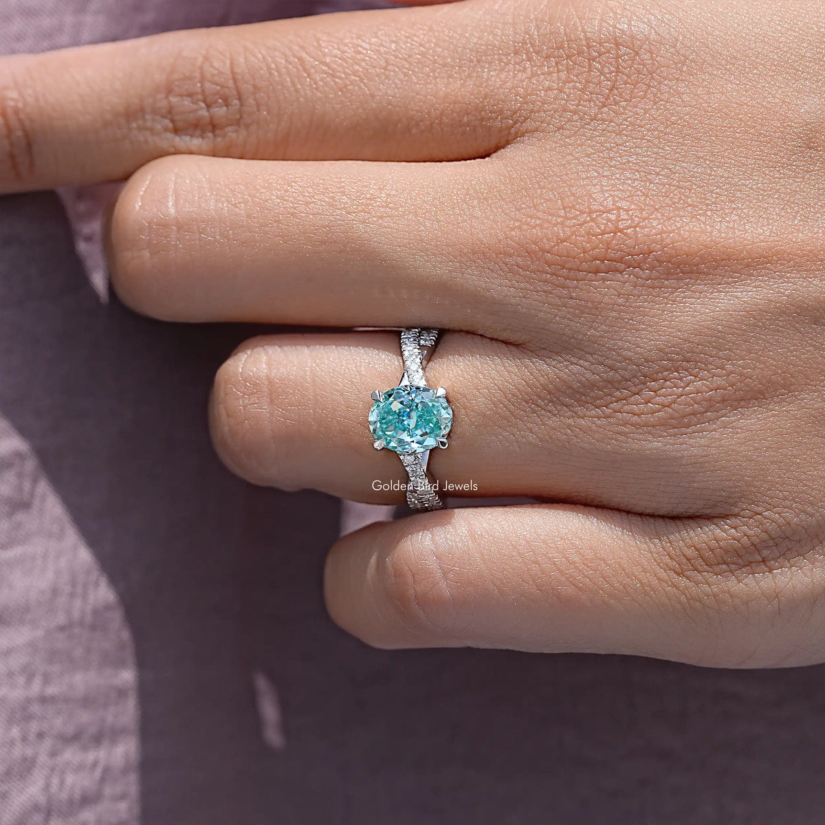 Sterling silver band with oval blue moissanite centerpiece and pave accents