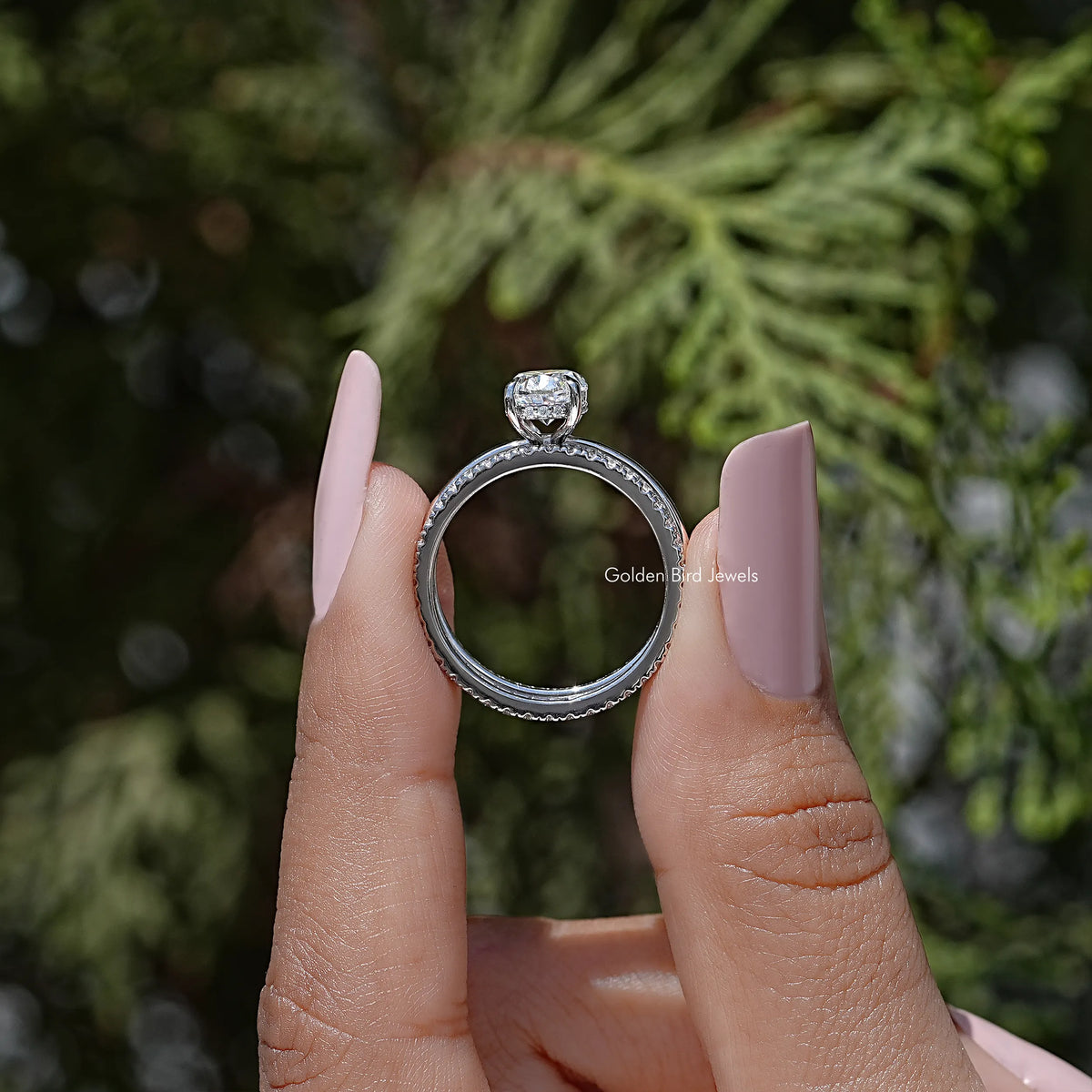 Moissanite bridal ring set viewed from the side, oval stone with halo-like top